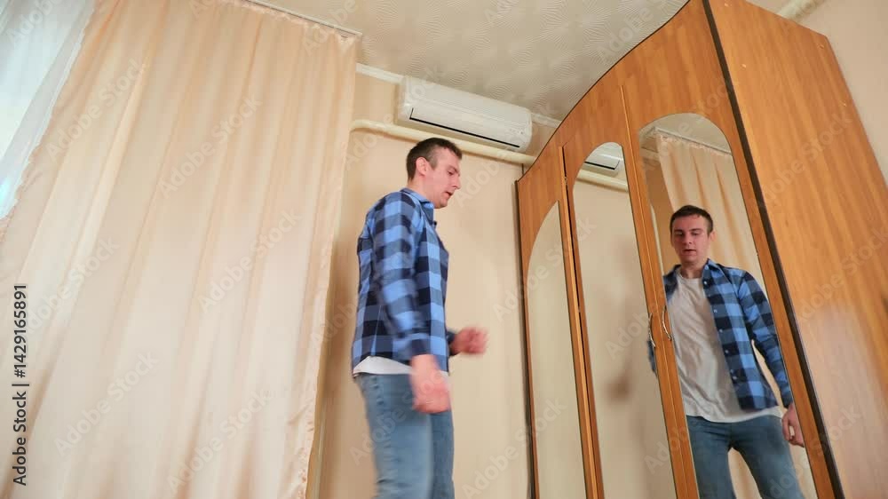 Energetic man having fun dancing to music with barefoot in a home bedroom interior Energetic man having fun dancing to music with barefoot in a home bedroom interior