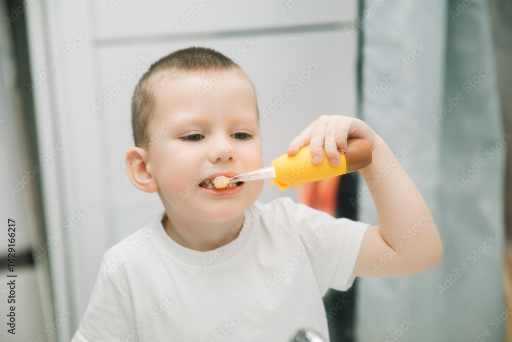 boy brushing teeth in bathroom in front of mirror. oral and dental hygiene. children's toothbrush with backlight boy brushing teeth in bathroom in front of mirror. oral and dental hygiene. children's toothbrush with backlight