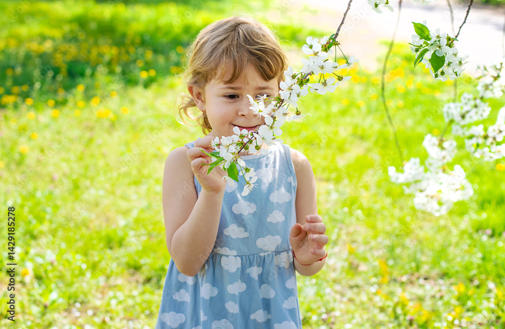 Child in a garden of flowering trees. Selective focus. Child in a garden of flowering trees. Selective focus.