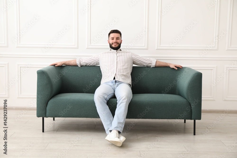 Smiling man relaxing on sofa at home Smiling man relaxing on sofa at home