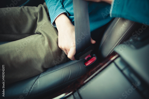 Child buckling seatbelt in car interior for safety