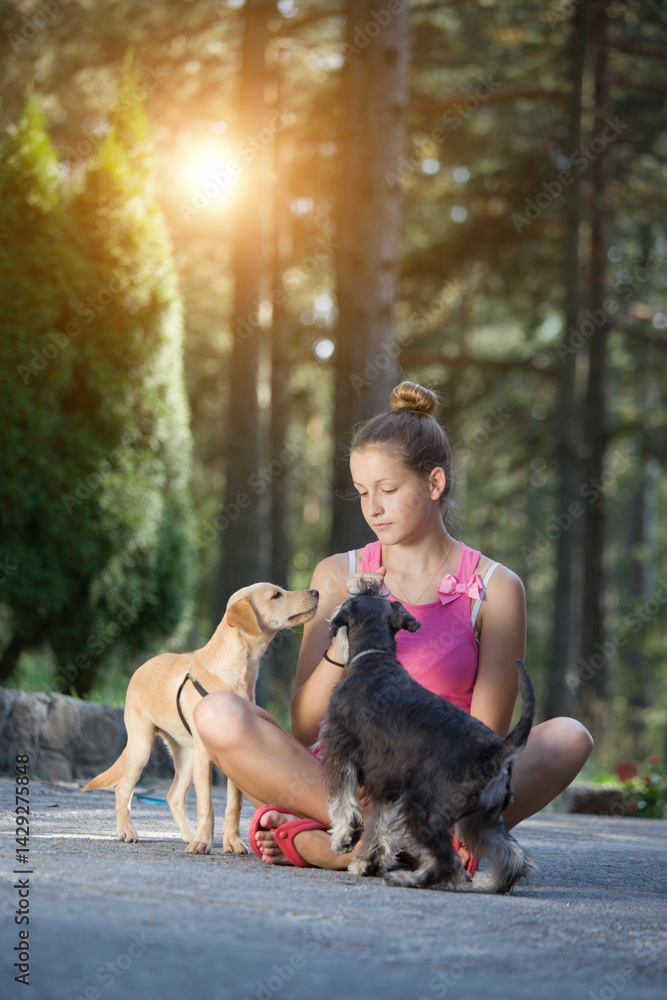 Obraz premium Girls and dogs having fun in nature