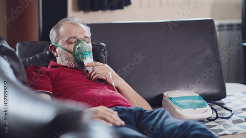 Middle-aged man using oxygen mask at home for breathing treatment