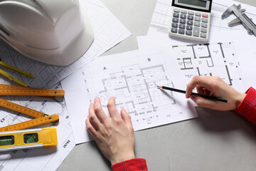 Architect working with project, closeup. Different technical drawings and construction tools on gray table