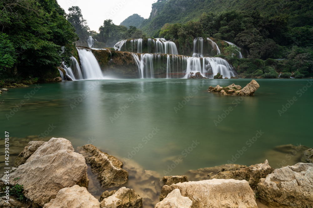 Fototapeta premium Detian Falls cascading into a tranquil green pond in Vietnam