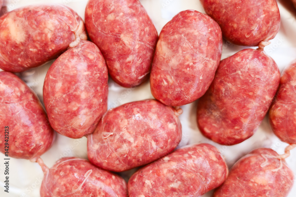 Freshly made sausages arranged neatly on a clean surface for culinary preparation Freshly made sausages arranged neatly on a clean surface for culinary preparation