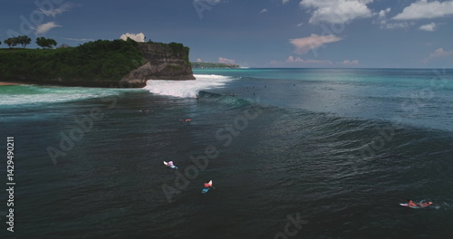 Obraz na płótnie Stunning aerial view of surfers riding waves at the famous Dreamland Beach on Bali island, Indonesia, with a dramatic cliff in the background and turquoise water w salonie