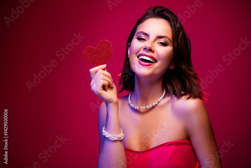 Quadro su tela Beautiful young woman wearing elegant dress and holding a heart shape with pink