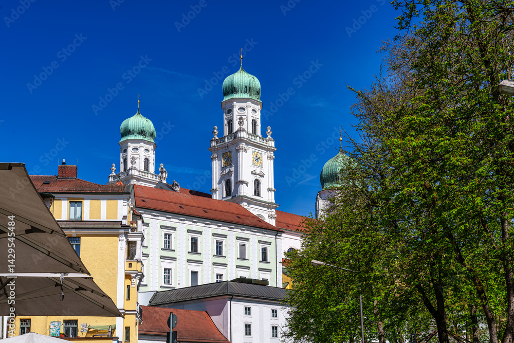 St. Stephans cathedral in Passau, Germany is an old white church with green metal domes on top of the towers