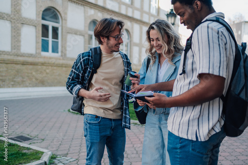 Φωτογραφία Students consulting a tourist guide during a university break