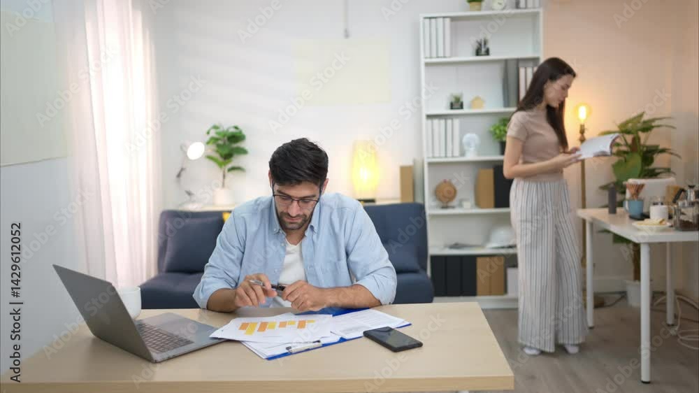 Portrait of a young freelancer smiling while working online via laptop at home with his girlfriend Portrait of a young freelancer smiling while working online via laptop at home with his girlfriend