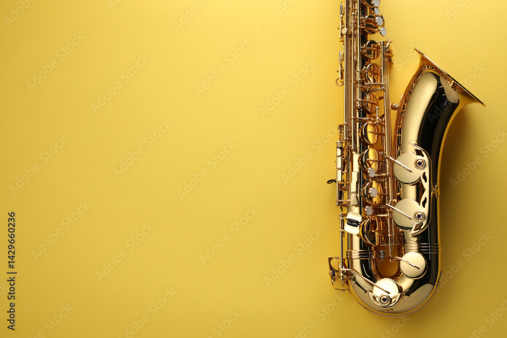 Naklejka premium Jazz. One saxophone on yellow background, top view. Space for text