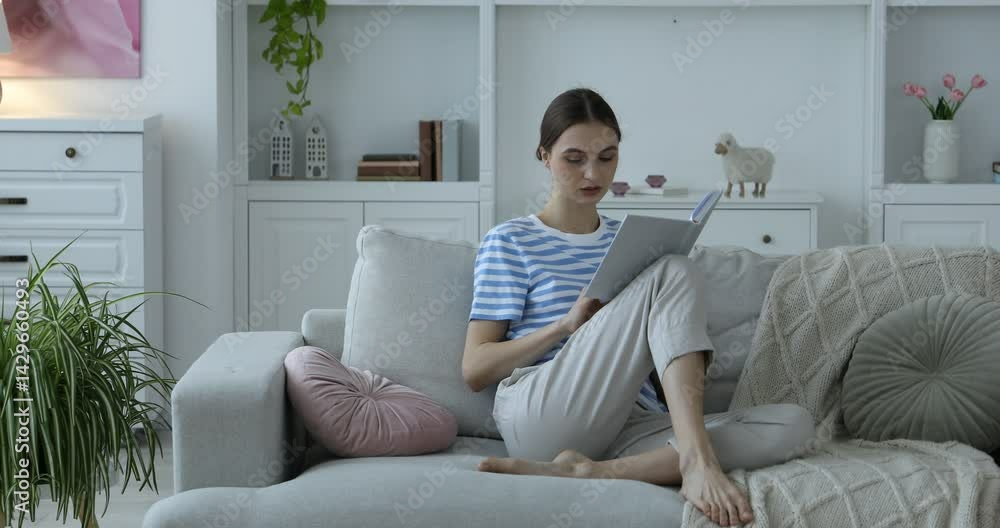 Beautiful woman reading book on comfortable sofa at home Beautiful woman reading book on comfortable sofa at home