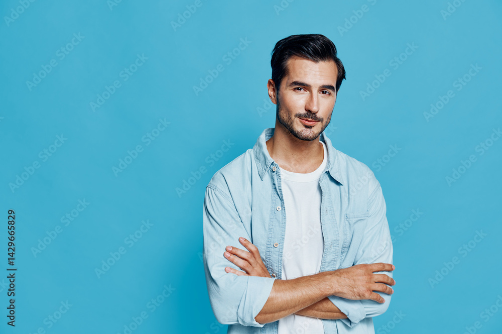 confident man with folded arms wearing light blue shirt and white t-shirt standing on blue background casual style smiling face portrait confident man with folded arms wearing light blue shirt and white t-shirt standing on blue background casual style smiling face portrait