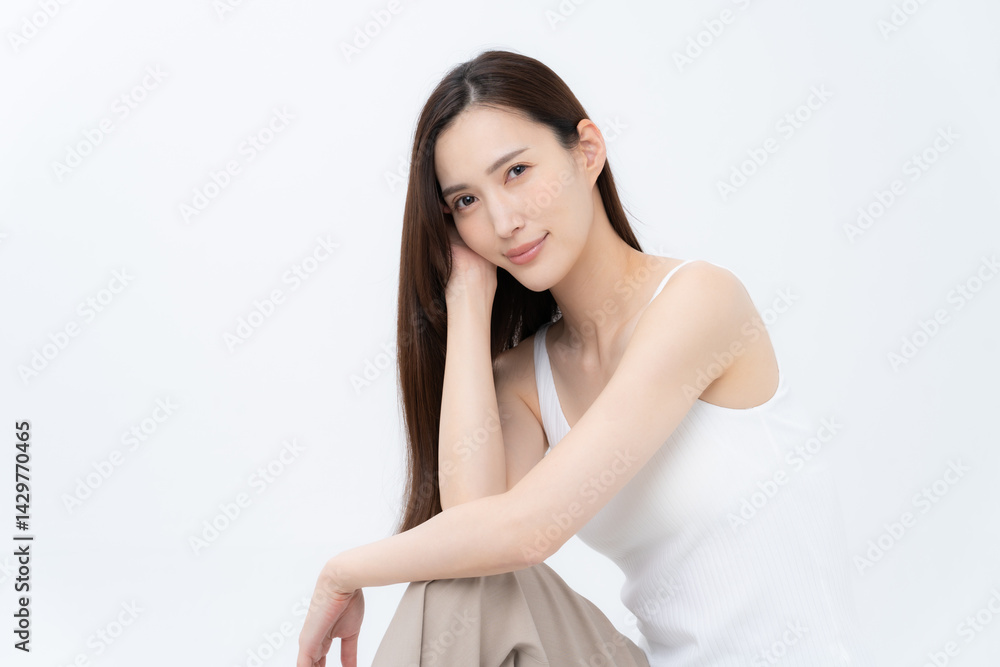 白バックでスキンケアをするロングヘアの若い女性 白バックでスキンケアをするロングヘアの若い女性