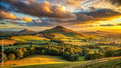 Soft golden light illuminates the Eildon Hills as a glowing sky appears in the distance , Landscape
