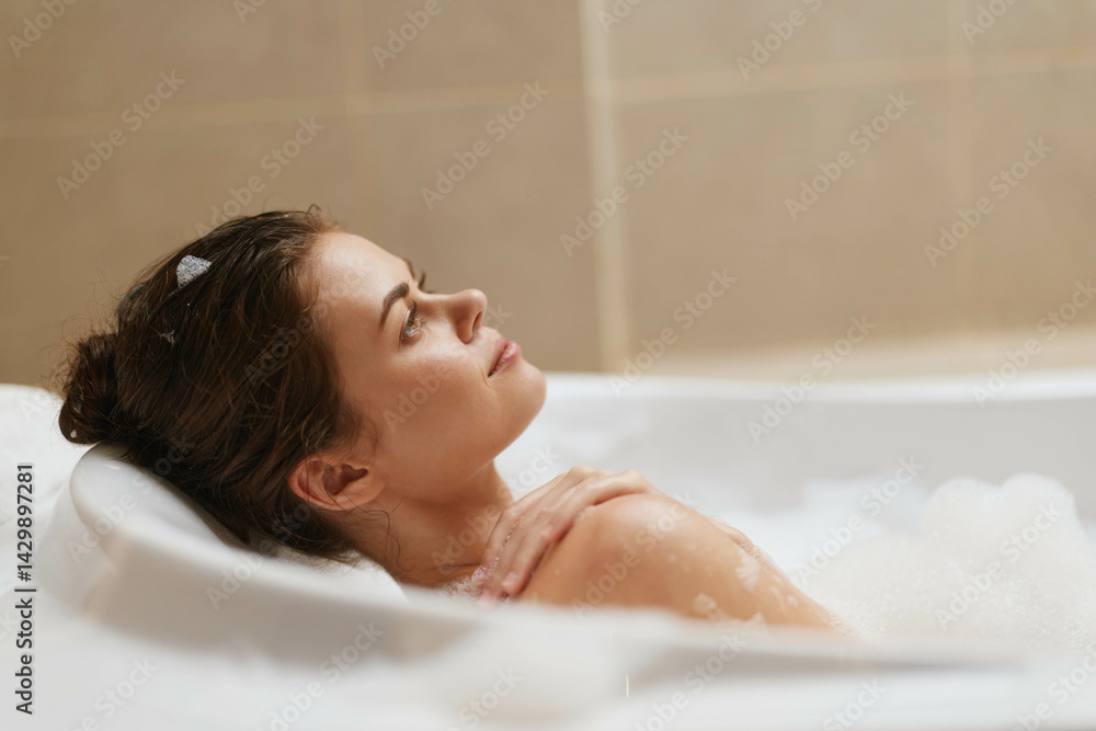 Obraz premium Relaxed woman enjoying a bubble bath, closed eyes and tranquil expression, surrounded by bubbles and soft lighting. Self-care and wellness concept.