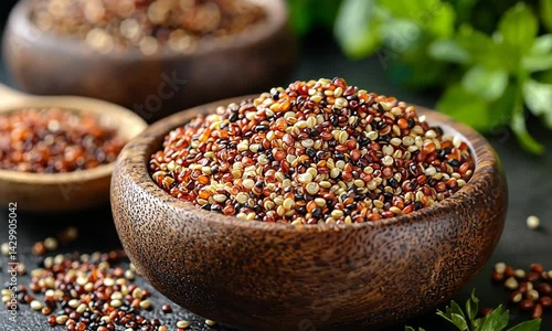 Wooden bowl filled with mixed quinoa grains.