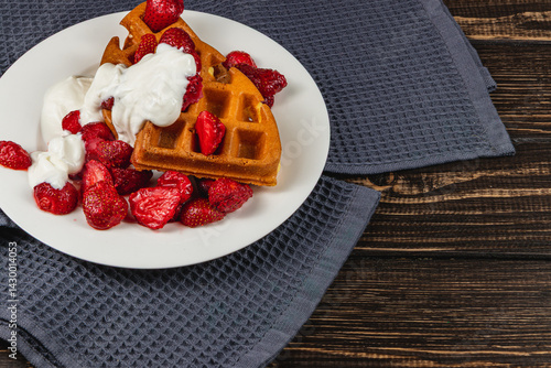 Delicious waffles topped with strawberries and cream