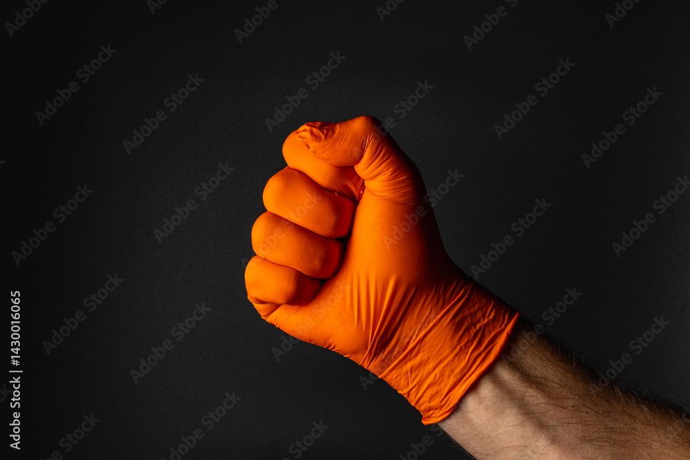 Gloved hand making a fist against a dark background