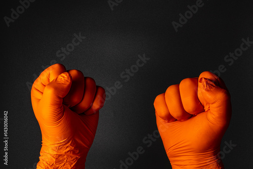 Obraz na płótnie Hands in orange gloves raised in solidarity during protest w salonie