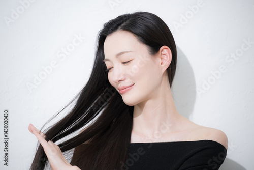 Canvas Print 黒髪のロングヘアを触る、美しい若い女性の艶と素肌感が美しいビューティーイメージの横顔のクローズアップ