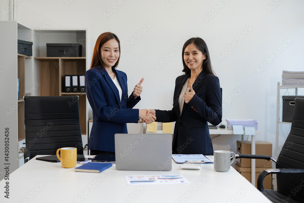 Asian businesswomen shaking hands at startup office meeting. Asian businesswomen shaking hands at startup office meeting.