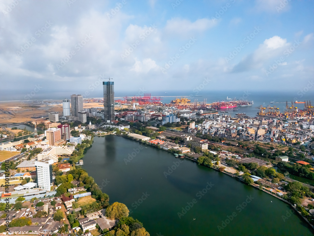 Fototapeta premium Aerial image of Colombo s container port with shipping terminals and logistics infrastructure. Ideal for international trade, freight transport, shipping, and urban industrial development.