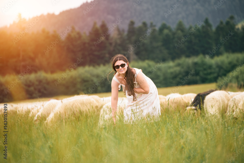 Woman crouching next to sheep outdoors