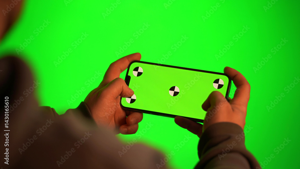 Man sitting at home using green screen phone
