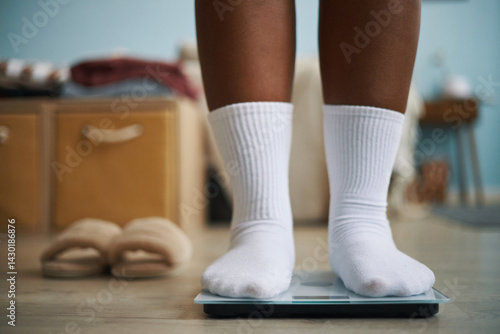 Cuadro en lienzo Close-up image showing feet in white socks standing on digital scale in cozy roo