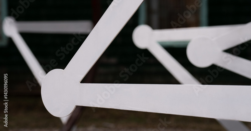 close up of white geometrical shapes of  bars with circles on the ends creating triangle shapes with black background empty framed space for type horizontal format with leading lines 