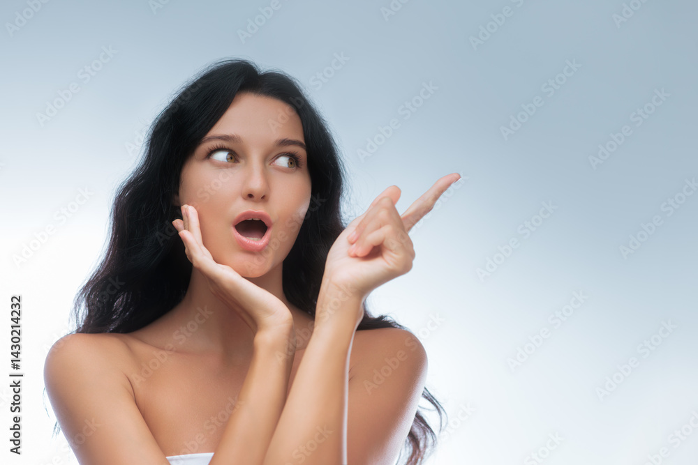 Close-up of a young woman with dark hair, showing a surprised and excited expression while pointing to the side. Great for concepts in advertising, lifestyle, and promotional materials.