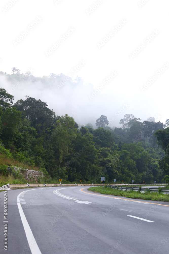 Empty road cutting through the mountains road and there was mist in the morning.