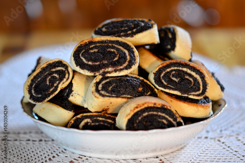 pile of poppy seed and walnut strudels in the ceramic bowl at the table