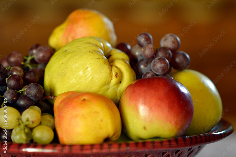 ceramic bowl with various ripe fruits at the table