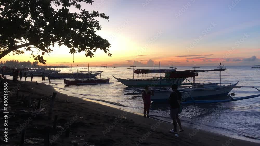 Silhouette of beautiful view of the morning activities of the fishermen and residents on the beach by the sea at sunrise. Silhouette of beautiful view of the morning activities of the fishermen and residents on the beach by the sea at sunrise.