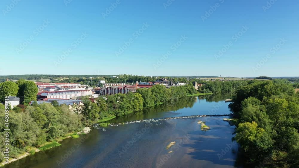 The Imphy factory located in front of the banks of the Loire in Europe, in France, in Burgundy, in Nievre, in summer, on a sunny day. The Imphy factory located in front of the banks of the Loire in Europe, in France, in Burgundy, in Nievre, in summer, on a sunny day.