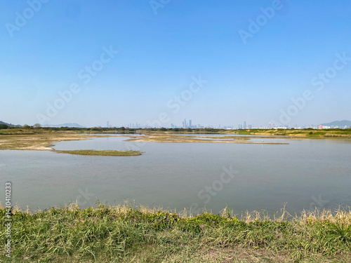 Obraz na płótnie Tranquil Wetland Lake Landscape with Distant Mountains and Clear Sky, Mei Po, Hong Kong w salonie