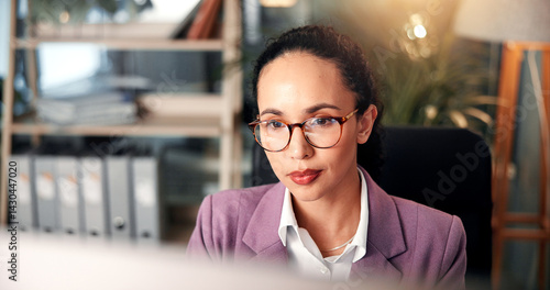 Computer, information and reading with business woman at desk for investment or portfolio management. Agenda, finance and glasses with stock market broker in workplace for strategy development