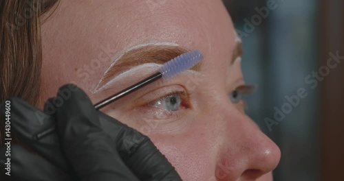 Close-up of a woman's face. The procedure for coloring and shaping eyebrows