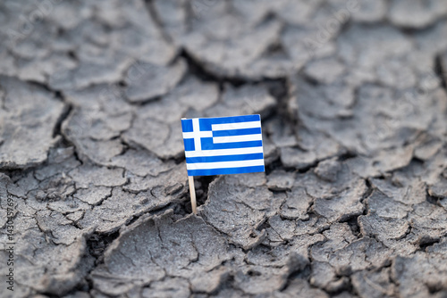 Fotografija Greek flag stuck in cracked dry earth