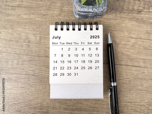 2025 July desk calendar flat lay on wooden table 