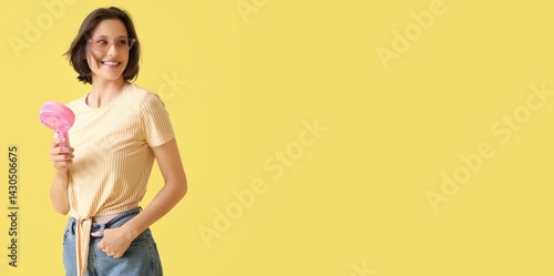 Young woman with mini fan o...