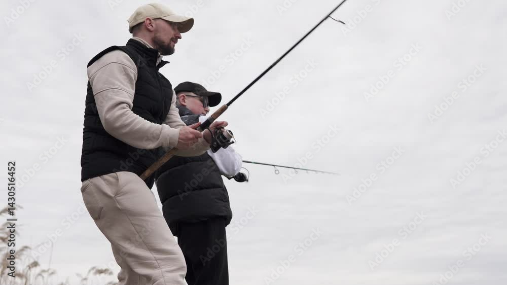 Father and son fishing on a wooden pier. Father teaching his child to fish. Fatherhood concept. Father and son fishing on a wooden pier. Father teaching his child to fish. Fatherhood concept.