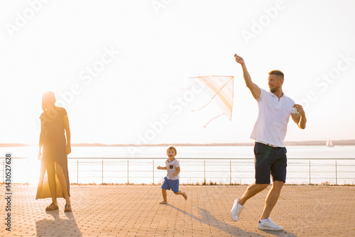 Obraz na płótnie Family Running Together With Flying Kite Outdoors w salonie