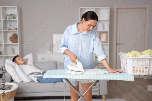 Wife ironing laundry while ...