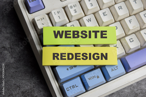 Fotografi Concept of Website redesign write on sticky notes isolated on Wooden Table