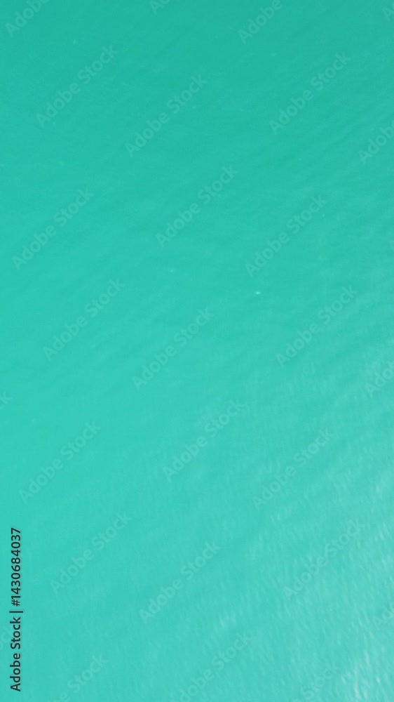 Vertical aerial view over calm azure sea water surface. Sun glare. Abstract nautical summer ocean nature. Holiday, vacation and travel concept. Nobody. Weather and climate change Vertical aerial view over calm azure sea water surface. Sun glare. Abstract nautical summer ocean nature. Holiday, vacation and travel concept. Nobody. Weather and climate change