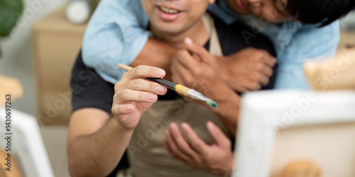 Couple and Painting Fun. A gay couple enjoying a playful moment while painting together in a cozy environment.